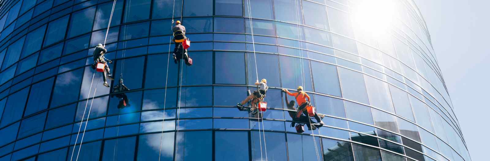 Varios operarios en limpieza de vidrios en altura